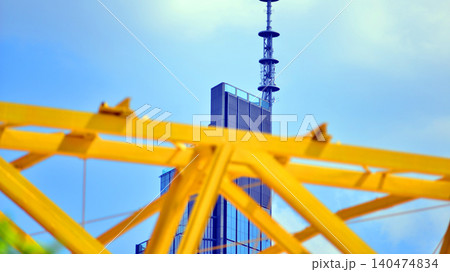 Yellow metal structure against the background of a skyscraper. Modern office building made of steel and glass Yellow metal structure against the background of a skyscraper. Modern office building made of steel and glass 140474834