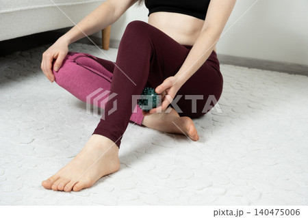 Woman Using Spiky Massage Ball for Calf Muscle Recovery. Woman Using Spiky Massage Ball for Calf Muscle Recovery. 140475006