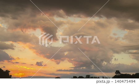 A picturesque sunset over the river with reflections of clouds and silhouettes of trees A picturesque sunset over the river with reflections of clouds and silhouettes of trees 140475494