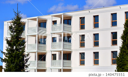 Modern residential structure showcasing a contemporary design with sloped roof, big windows and balconies. 140475551