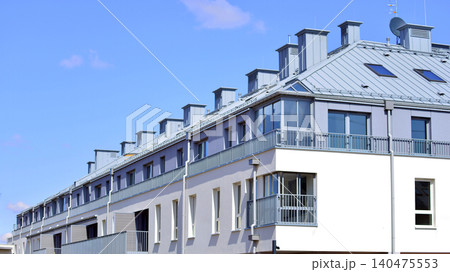 Modern residential structure showcasing a contemporary design with sloped roof, big windows and balconies. Modern residential structure showcasing a contemporary design with sloped roof, big windows and balconies. 140475553