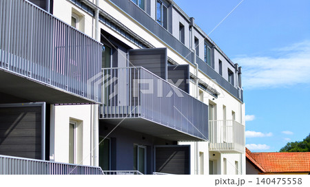 Modern residential structure showcasing a contemporary design with sloped roof, big windows and balconies. Modern residential structure showcasing a contemporary design with sloped roof, big windows and balconies. 140475558