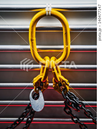 Bright yellow chain link secured with a lock on metallic background at a construction site during the day Bright yellow chain link secured with a lock on metallic background at a construction site during the day 140477147