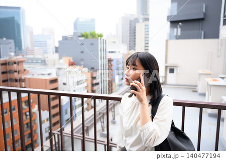 都会の屋上で電話する女性 都会の屋上で電話する女性 140477194