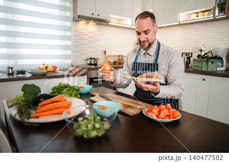Man learning new recipe in kitchen preparing healthy meal 140477502