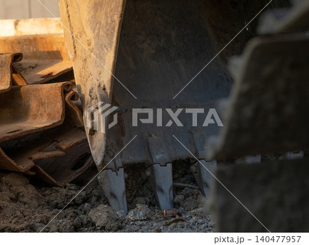 Digger parked at construction site with metal bar. Backhoe after work. Earth moving machine. Excavation vehicle. Construction site with excavator. Infrastructure development. Construction industry. 140477957