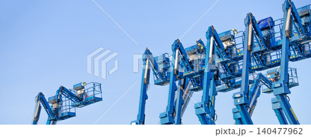 Articulated boom lift. Aerial platform lift. Telescopic boom lift against clear sky. Mobile construction crane for rent and sale. Maintenance and repair hydraulic boom lift service. Crane dealership. Articulated boom lift. Aerial platform lift. Telescopic boom lift against clear sky. Mobile construction crane for rent and sale. Maintenance and repair hydraulic boom lift service. Crane dealership. 140477962