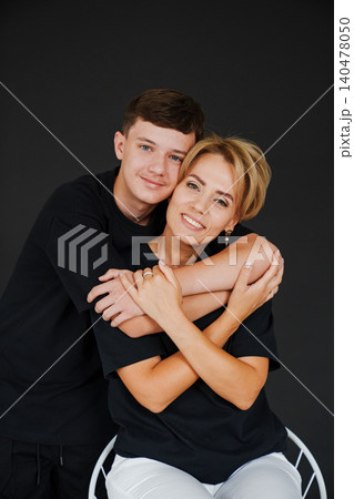 Mother and son share a warm moment while posing together in studio Mother and son share a warm moment while posing together in studio 140478050