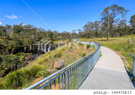 Scenic view of Ebor Falls and surrounding natural landscape in New South Wales, Australia. Waterfall cascading over rock formation within forest environment of Guy Fawkes River National Park. 140478615