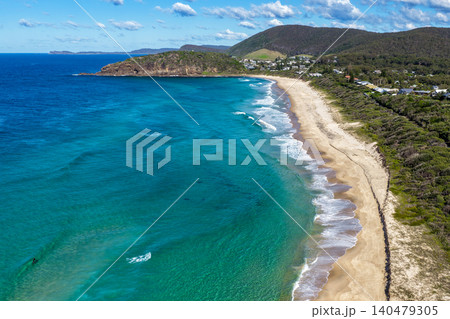 Aerial scene capturing Boomerang Beach near Pacific Palms, NSW, Australia, looking towards Boomerang Point. The sweeping sandy shoreline, clear ocean waters and prominent coastal headland Aerial scene capturing Boomerang Beach near Pacific Palms, NSW, Australia, looking towards Boomerang Point. The sweeping sandy shoreline, clear ocean waters and prominent coastal headland 140479305
