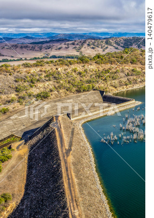 Vertical Aerial view of Glenbawn Dam and the spillway with surrounding landscape in NSW Australia. Drone photograph captures the engineering infrastructure, expansive reservoir and rugged inland Vertical Aerial view of Glenbawn Dam and the spillway with surrounding landscape in NSW Australia. Drone photograph captures the engineering infrastructure, expansive reservoir and rugged inland 140479617