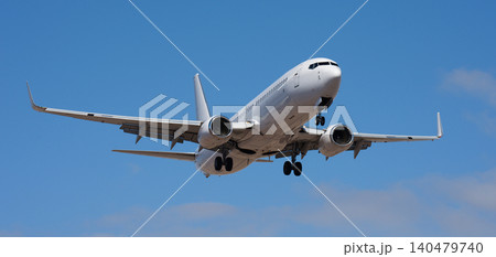 The plane lands. Airplane, passengers flying in the blue sky, preparing to land at the airport The plane lands. Airplane, passengers flying in the blue sky, preparing to land at the airport 140479740