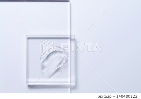 A sample of a transparent cosmetic skin care product on glass. Blue background A sample of a transparent cosmetic skin care product on glass. Blue background 140480122