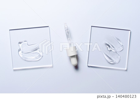 A sample of a transparent cosmetic skin care product on glass. Blue background 140480123