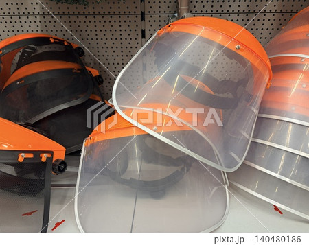 Protective face shields arranged on a retail store shelf. A hardware or safety equipment store setting Protective face shields arranged on a retail store shelf. A hardware or safety equipment store setting 140480186