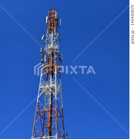 Colorful communications mast. Industrial tower showcasing weathered steel framework and devices Colorful communications mast. Industrial tower showcasing weathered steel framework and devices 140480670