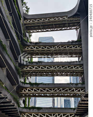 Concrete balconies rising in stark geometry, towering facade with deep shadows and rough texture Concrete balconies rising in stark geometry, towering facade with deep shadows and rough texture 140480715