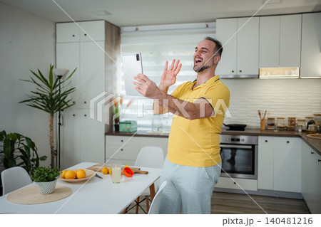 Man making video call from home kitchen Man making video call from home kitchen 140481216