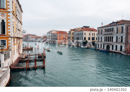 Boats travel along the Grand Canal in Venice during a cloudy afternoon Boats travel along the Grand Canal in Venice during a cloudy afternoon 140481302