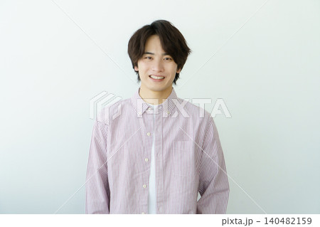 白背景の縦縞ののシャツを着る若い日本人男性のポートレート 140482159