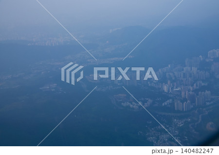 Looking from the airplane window with Hong Kong cityscape. The view of Hong Kong city, Hong Kong landscape from the above. Landscape, travel concept and nature scene.  140482247