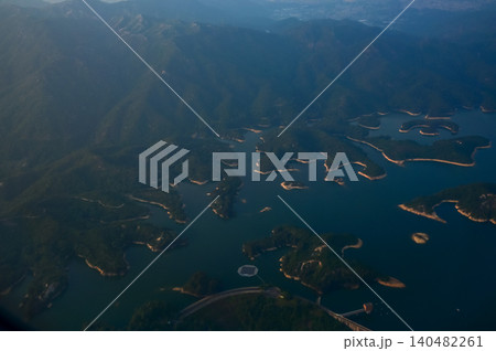 Looking from the airplane window with Hong Kong cityscape. The view of Hong Kong city, Hong Kong landscape from the above. Landscape, travel concept and nature scene.  140482261