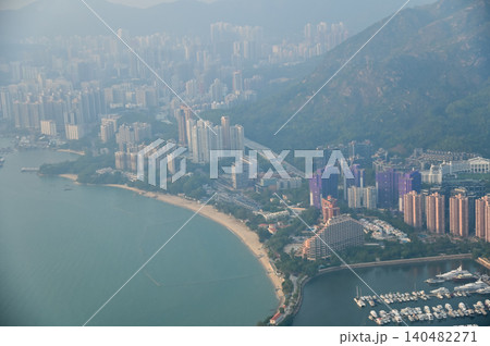 Looking from the airplane window with Hong Kong cityscape. The view of Hong Kong city, Hong Kong landscape from the above. Landscape, travel concept and nature scene. Looking from the airplane window with Hong Kong cityscape. The view of Hong Kong city, Hong Kong landscape from the above. Landscape, travel concept and nature scene. 140482271