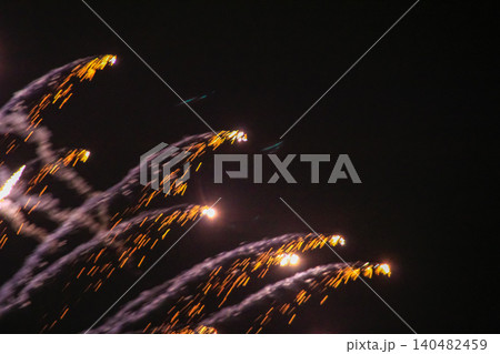 Stunning and colorful fireworks display in the night sky. Real fireworks background. Abstract of real shining fireworks against black background. Glowing fireworks show for celebration. Stunning and colorful fireworks display in the night sky. Real fireworks background. Abstract of real shining fireworks against black background. Glowing fireworks show for celebration. 140482459