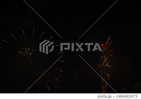 Stunning and colorful fireworks display in the night sky. Real fireworks background. Abstract of real shining fireworks against black background. Glowing fireworks show for celebration. Stunning and colorful fireworks display in the night sky. Real fireworks background. Abstract of real shining fireworks against black background. Glowing fireworks show for celebration. 140482473