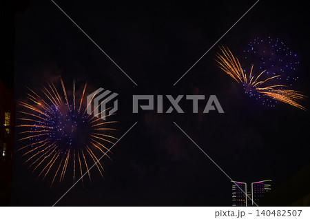 Stunning and colorful fireworks display in the night sky. Real fireworks background. Abstract of real shining fireworks against black background. Glowing fireworks show for celebration. Stunning and colorful fireworks display in the night sky. Real fireworks background. Abstract of real shining fireworks against black background. Glowing fireworks show for celebration. 140482507