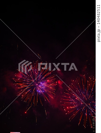 Stunning and colorful fireworks display in the night sky. Real fireworks background. Abstract of real shining fireworks against black background. Glowing fireworks show for celebration. Stunning and colorful fireworks display in the night sky. Real fireworks background. Abstract of real shining fireworks against black background. Glowing fireworks show for celebration. 140482511