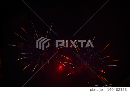 Stunning and colorful fireworks display in the night sky. Real fireworks background. Abstract of real shining fireworks against black background. Glowing fireworks show for celebration. Stunning and colorful fireworks display in the night sky. Real fireworks background. Abstract of real shining fireworks against black background. Glowing fireworks show for celebration. 140482528