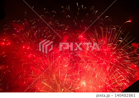 Stunning and colorful fireworks display in the night sky. Real fireworks background. Abstract of real shining fireworks against black background. Glowing fireworks show for celebration. 140482861