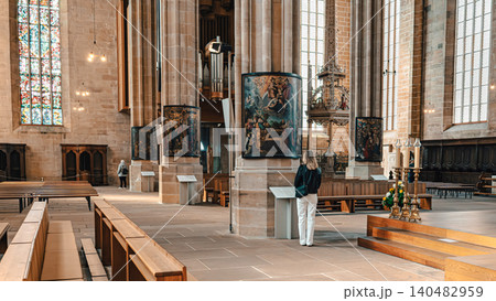 Erfurt, Germany - March 27, 2026. Woman Viewing Art in Historic Church Erfurt, Germany - March 27, 2026. Woman Viewing Art in Historic Church 140482959