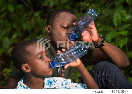 a family in the countryside with a bottle of water. a family in the countryside with a bottle of water. 140483078