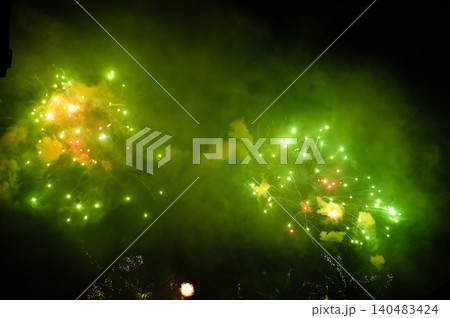 Stunning and colorful fireworks display in the night sky with smoke during explosion. Real fireworks background. Abstract of real shining fireworks against black background. for celebration. Stunning and colorful fireworks display in the night sky with smoke during explosion. Real fireworks background. Abstract of real shining fireworks against black background. for celebration. 140483424