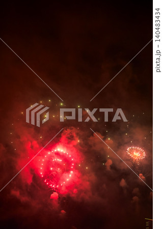 Stunning and colorful fireworks display in the night sky with smoke during explosion. Real fireworks background. Abstract of real shining fireworks against black background. for celebration. Stunning and colorful fireworks display in the night sky with smoke during explosion. Real fireworks background. Abstract of real shining fireworks against black background. for celebration. 140483434