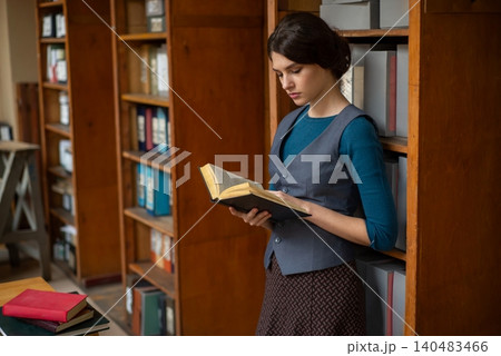 Young woman reading a book in the library Young woman reading a book in the library 140483466