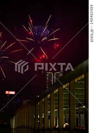 Stunning and colorful fireworks display in the night sky with Hong Kong city background. Watching the fireworks from the bridge. Real fireworks background. For celebration. Stunning and colorful fireworks display in the night sky with Hong Kong city background. Watching the fireworks from the bridge. Real fireworks background. For celebration. 140483484