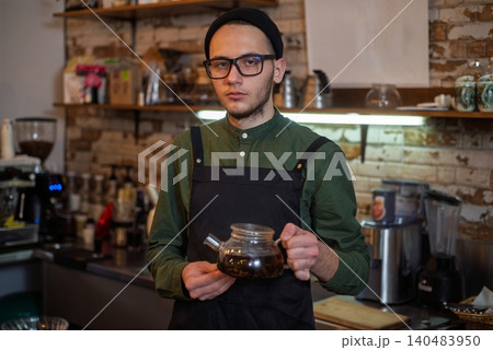 A male barista making alternative filter coffee with a glass server into a cup 140483950