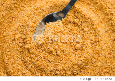 Golden cane sugar mound, spoon nestled within. Fine sweet granules Golden cane sugar mound, spoon nestled within. Fine sweet granules 140485628