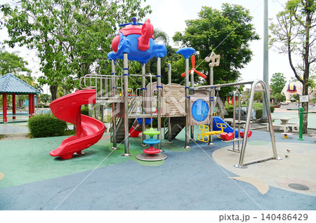 A large outdoor playground for children with a variety of play equipment, which is part of the public park. A large outdoor playground for children with a variety of play equipment, which is part of the public park. 140486429