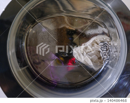 The washing machine washes dirty colored clothes 140486468