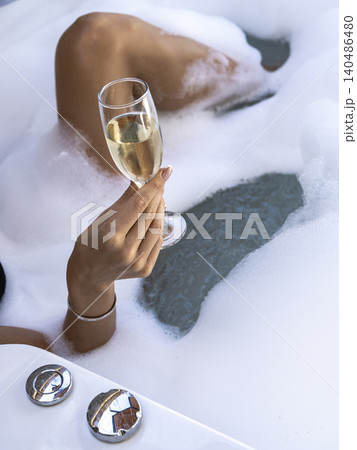 a woman drinking champagne in the jacuzzi a woman drinking champagne in the jacuzzi 140486480