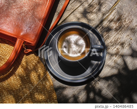 Straw hat, orange bag and delicious coffee on the wooden table Straw hat, orange bag and delicious coffee on the wooden table 140486485