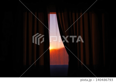 First rays of sunrise illuminating a window with flowing curtains in a tranquil setting First rays of sunrise illuminating a window with flowing curtains in a tranquil setting 140486793