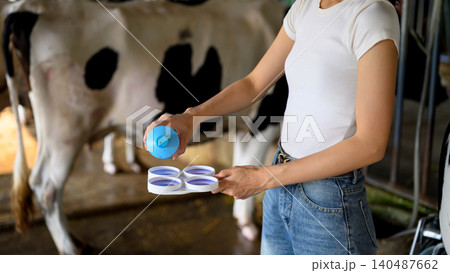 Closeup Dairy worker applying milk quality testing before milking process in farm Closeup Dairy worker applying milk quality testing before milking process in farm 140487662