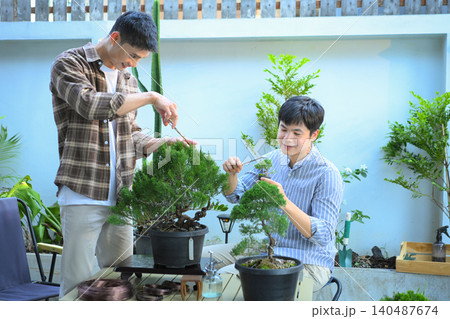 Couple LGBT pruning bonsai together in a peaceful home garden Couple LGBT pruning bonsai together in a peaceful home garden 140487674