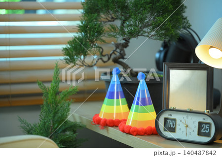 Rainbow party hats on shelf with home decor, Colorful pride themed objects in modern living space Rainbow party hats on shelf with home decor, Colorful pride themed objects in modern living space 140487842