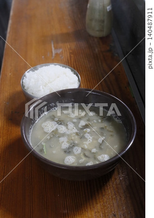 Bowl of Soup and Rice on Wooden Table 140487911